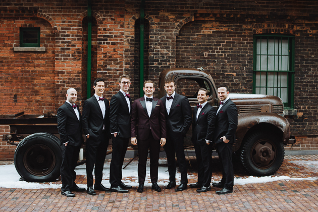Fermenting Cellar Toronto Wedding. Outdoor creative portrait session with the groom and his groomsment. Exposed aged brick walls, an old rusty truck and paved streets create a texturally rich and warm backdrop.
