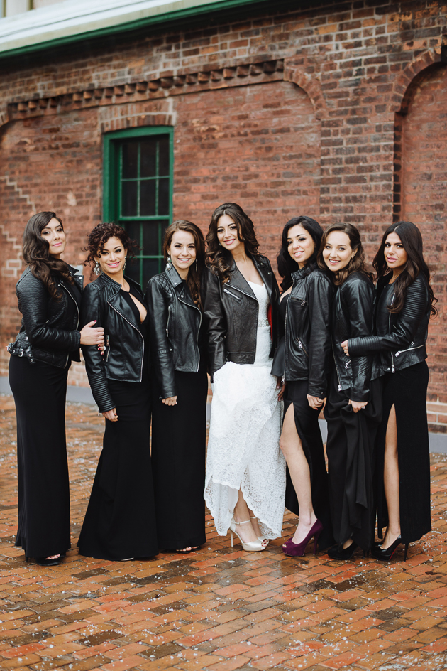 Fermenting Cellar Toronto Wedding. Outdoor creative portrait session with the bride and her bridesmaids styled in black dresses and black leather jackets in the Distillery District.